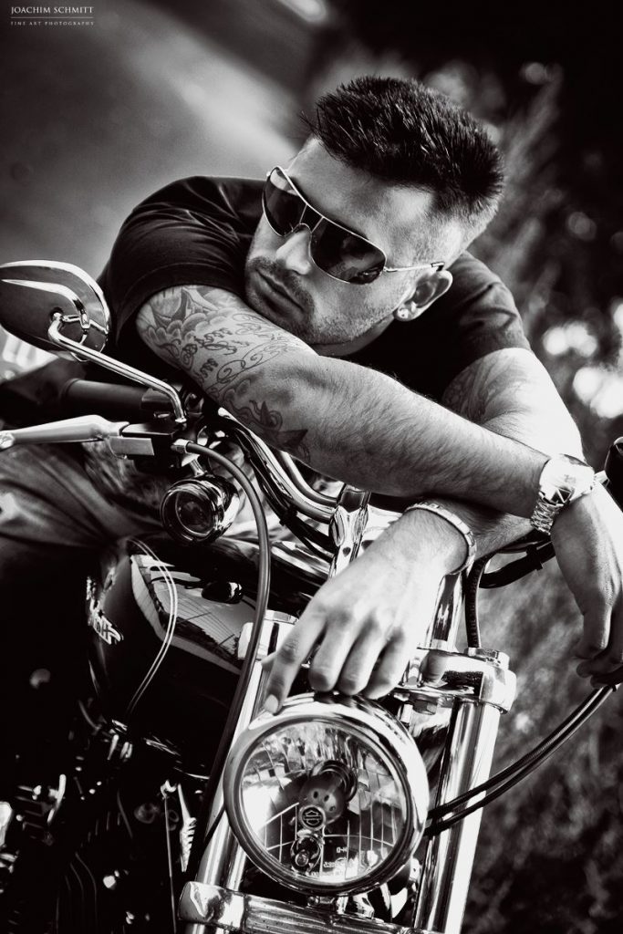 Ein Mann mit Sonnenbrille sitzt auf einem Motorrad