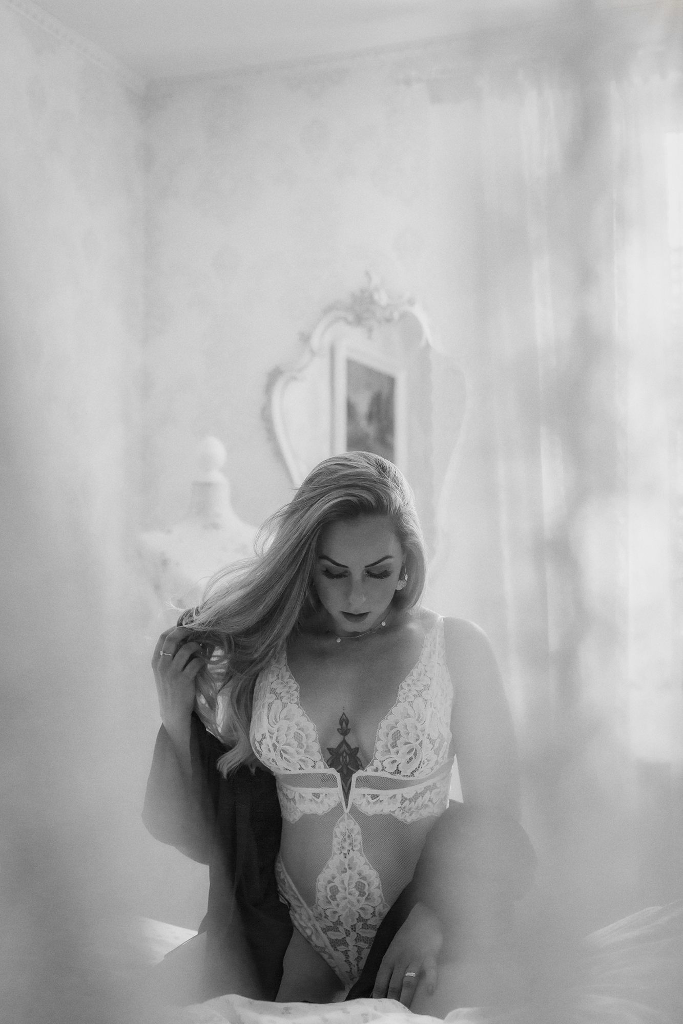 Eine Frau in Dessous sitzt auf einem Bett.